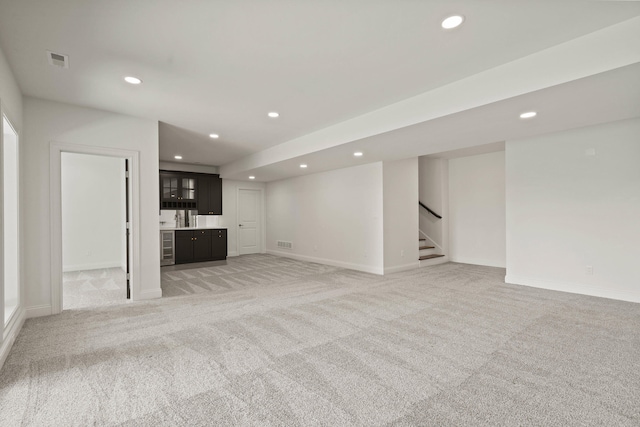 3001 Rivington Dr, Columbia, MO 65203 - unfurnished living room featuring light colored carpet, recessed lighting, stairway, and bar
