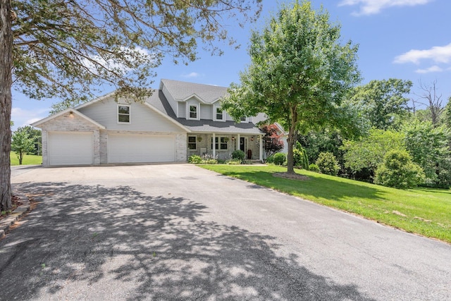 10550 E David Allen Rd, Columbia, MO 65201 - view of front of property with concrete driveway, an attached garage, a front yard, a porch, and stone siding