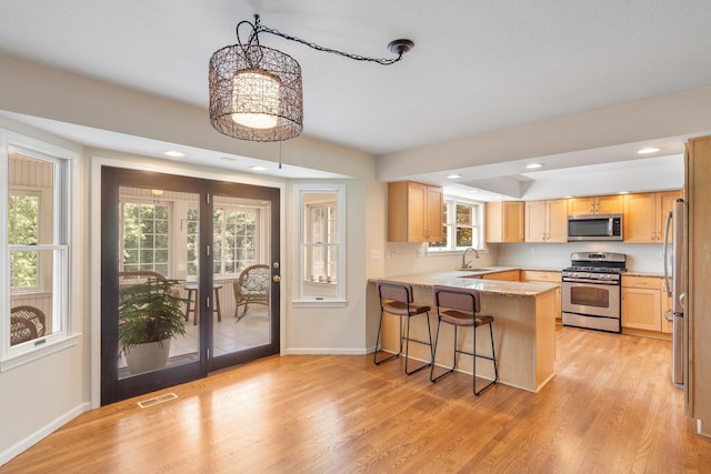 10550 E David Allen Rd, Columbia, MO 65201 - kitchen featuring stainless steel appliances, a peninsula, light wood-style flooring, light brown cabinets, and recessed lighting