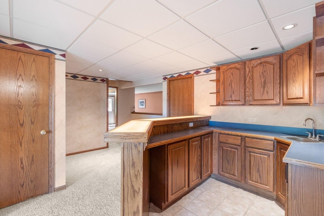 10550 E David Allen Rd, Columbia, MO 65201 - kitchen featuring a peninsula, a paneled ceiling, brown cabinetry, open shelves, and light carpet