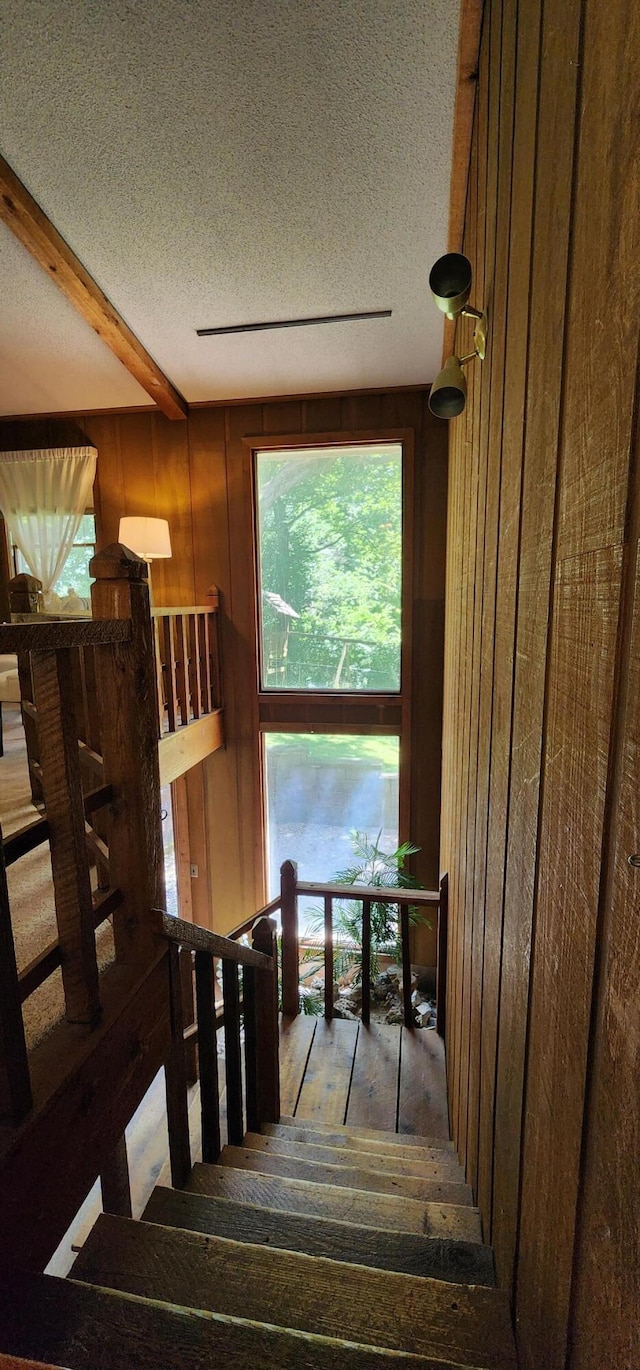 2716 Shagbark Cir, Jefferson City, MO 65109 - stairs featuring wood walls, a textured ceiling, beamed ceiling, and wood finished floors