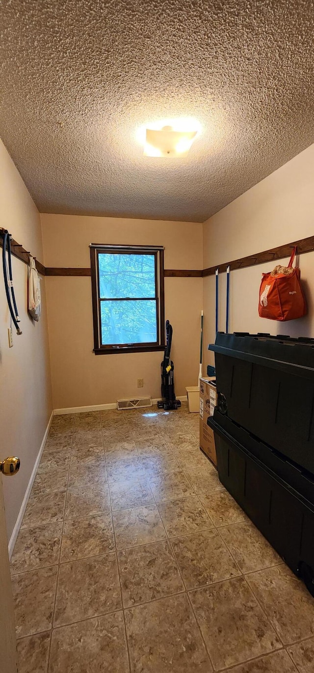2716 Shagbark Cir, Jefferson City, MO 65109 - unfurnished bedroom with a textured ceiling and tile patterned floors