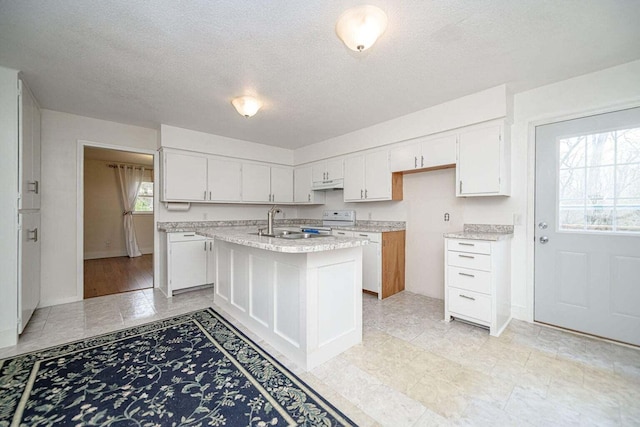 2130 E 163, Columbia, MO 65201 - kitchen with electric range, under cabinet range hood, white cabinetry, a textured ceiling, and an island with sink