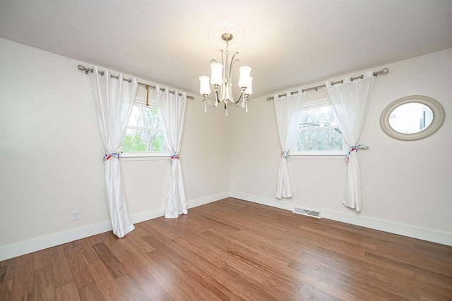 2130 E 163, Columbia, MO 65201 - empty room featuring a chandelier, healthy amount of natural light, and wood finished floors