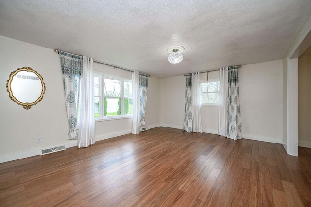 2130 E 163, Columbia, MO 65201 - empty room featuring healthy amount of natural light, a textured ceiling, and wood finished floors