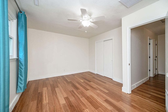 2130 E 163, Columbia, MO 65201 - unfurnished bedroom featuring wood finished floors, a closet, a ceiling fan, and a textured ceiling