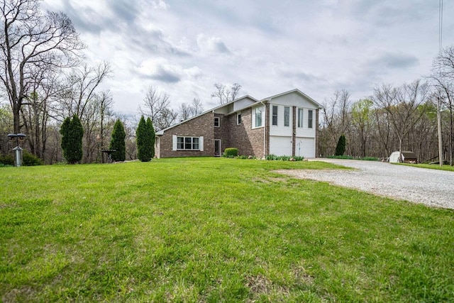 2130 E 163, Columbia, MO 65201 - view of front of home featuring an attached garage, brick siding, gravel driveway, and a front lawn