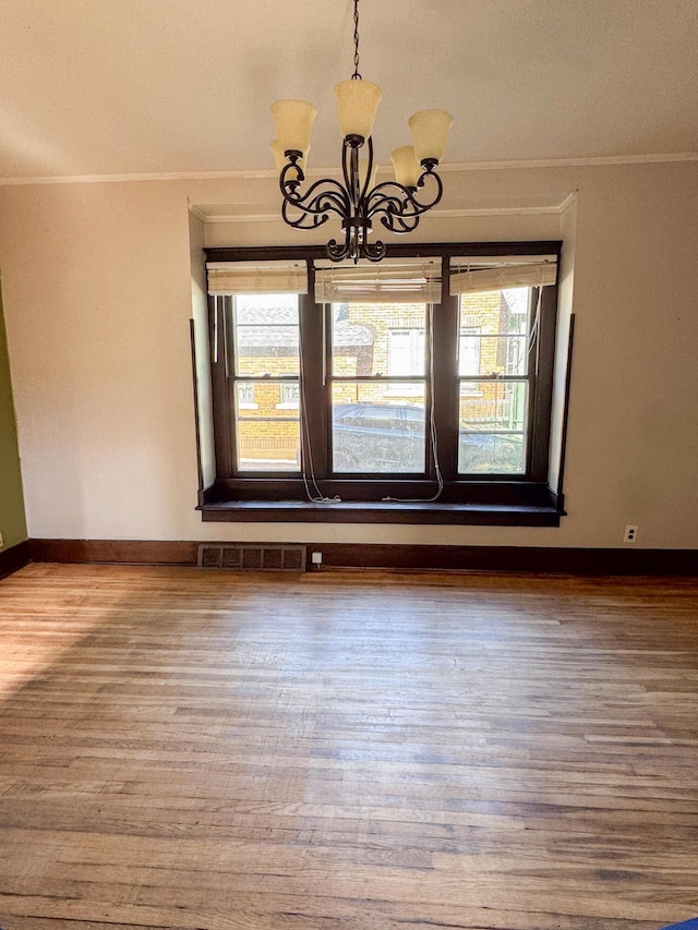 632 W Logan St, Moberly, MO 65270 - unfurnished room with ornamental molding, wood finished floors, and a chandelier