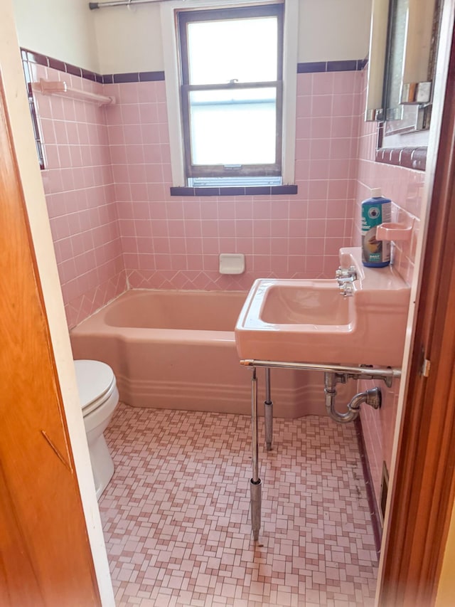 632 W Logan St, Moberly, MO 65270 - bathroom featuring tile walls, tile patterned floors, and a wainscoted wall