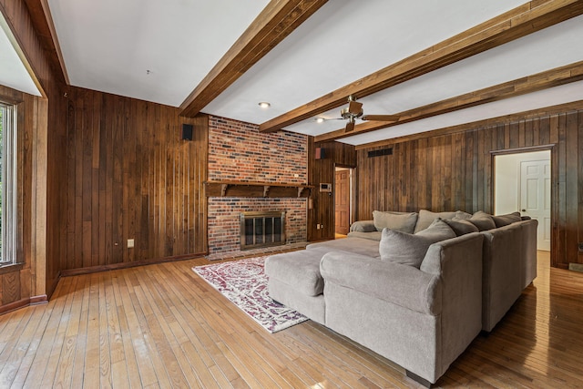 450 W Covered Bridge Rd, Columbia, MO 65203 - living room with wooden walls, beam ceiling, hardwood / wood-style flooring, and a fireplace