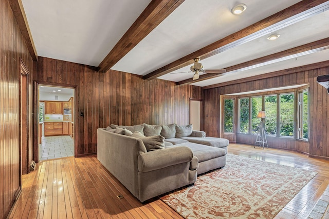 450 W Covered Bridge Rd, Columbia, MO 65203 - living room featuring wood walls, light wood-style flooring, beamed ceiling, and ceiling fan