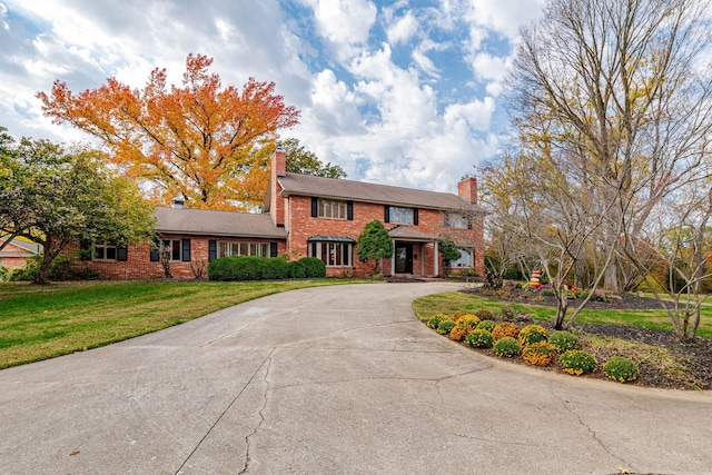 450 W Covered Bridge Rd, Columbia, MO 65203 - colonial-style house with brick siding, a chimney, curved driveway, and a front lawn