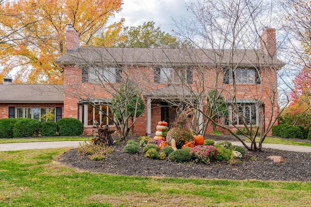 450 W Covered Bridge Rd, Columbia, MO 65203 - traditional home featuring a chimney, brick siding, and a front lawn