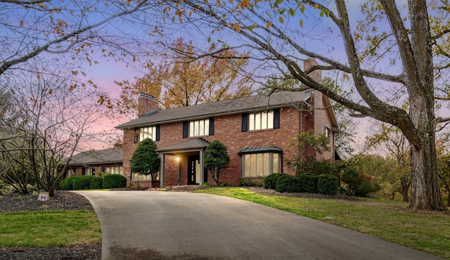450 W Covered Bridge Rd, Columbia, MO 65203 - view of front of home with a chimney, brick siding, driveway, and a front yard