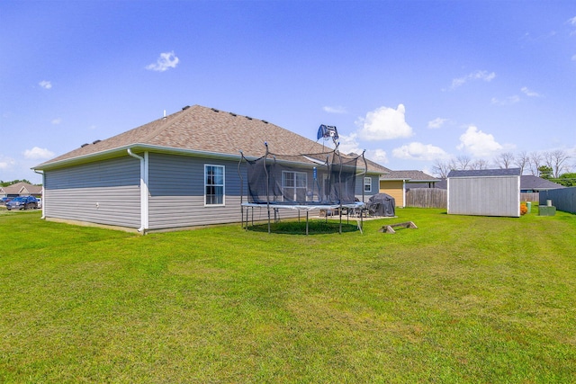 925 Kelli Ct, Centralia, MO 65240 - back of property featuring a trampoline, a storage shed, and roof with shingles