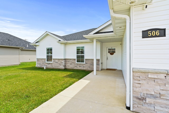 506 Addie Ln, Centralia, MO 65240 - property entrance with a lawn, roof with shingles, and stone siding