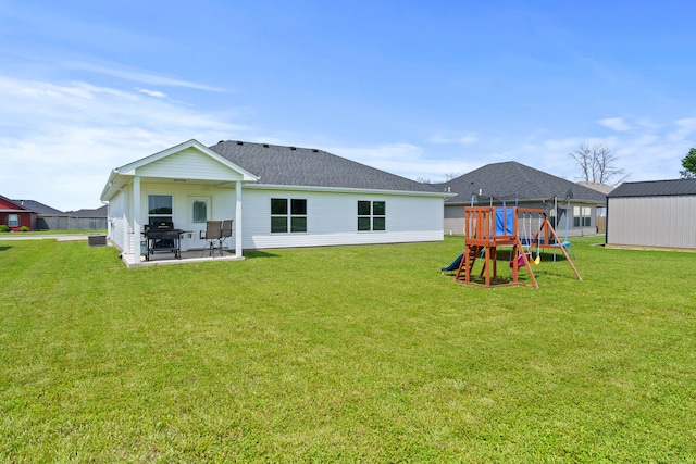 506 Addie Ln, Centralia, MO 65240 - rear view of property with a playground, a yard, a patio area, and a shingled roof