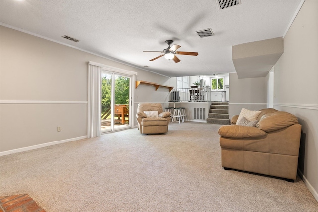 133 Manview Ln, Holts Summit, MO 65043 - carpeted living room featuring healthy amount of natural light, ceiling fan, ornamental molding, and a textured ceiling