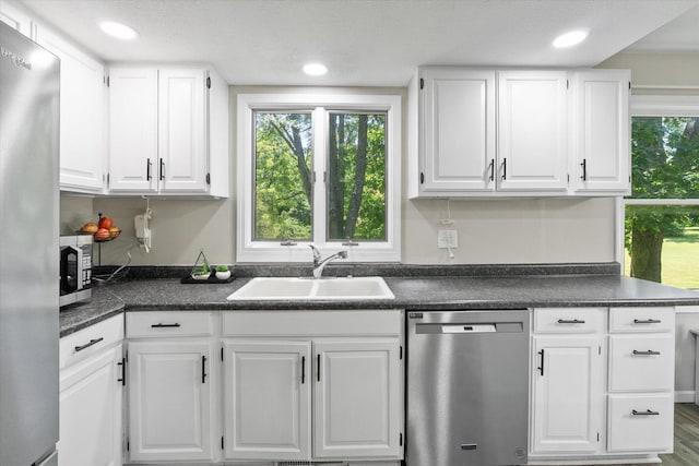 133 Manview Ln, Holts Summit, MO 65043 - kitchen with stainless steel appliances, dark countertops, white cabinets, recessed lighting, and wood finished floors