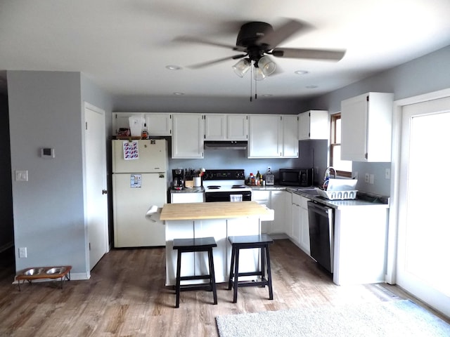 1008 Fairview St, Centralia, MO 65240 - kitchen featuring freestanding refrigerator, range with electric stovetop, a ceiling fan, white cabinetry, and recessed lighting