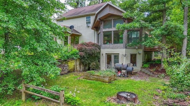 4241 E Ketterer Rd, Columbia, MO 65202 - rear view of property with a sunroom, a vegetable garden, and a fire pit