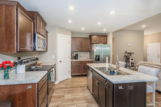 2905 N N Garth Ave, Columbia, MO 65202 - kitchen featuring appliances with stainless steel finishes, a breakfast bar, light wood-style floors, light countertops, and recessed lighting