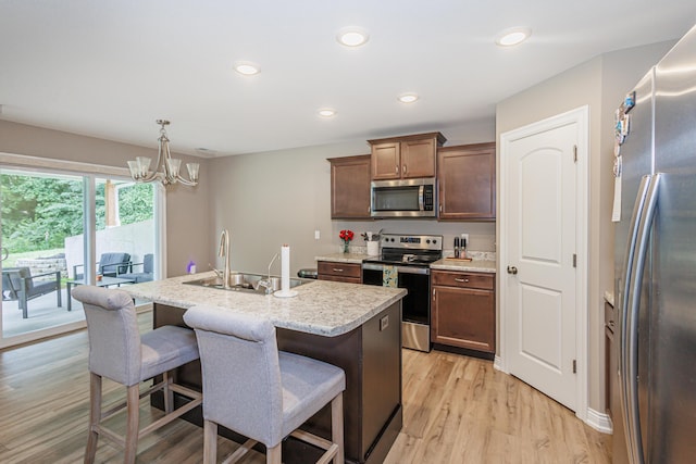 2905 N N Garth Ave, Columbia, MO 65202 - kitchen featuring appliances with stainless steel finishes, a chandelier, light wood-type flooring, a center island with sink, and recessed lighting