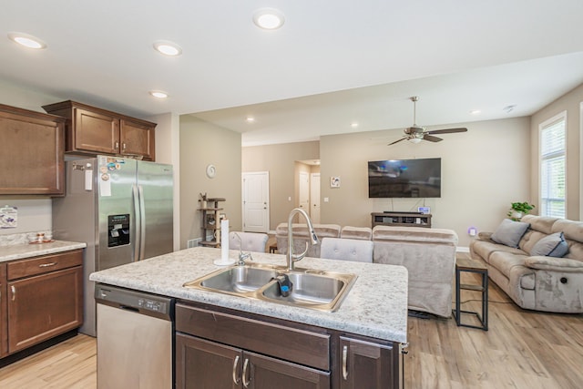 2905 N N Garth Ave, Columbia, MO 65202 - kitchen featuring stainless steel dishwasher, light wood-style flooring, an island with sink, open floor plan, and a ceiling fan