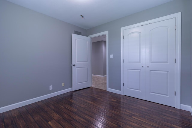 7700 N Ballew Rd, Hallsville, MO 65255 - unfurnished bedroom with dark wood-style flooring and a closet