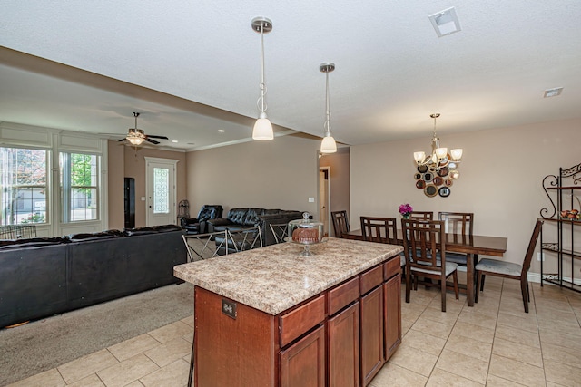3405 Piranha Ct, Columbia, MO 65202 - kitchen with light countertops, decorative light fixtures, a center island, brown cabinetry, and ceiling fan