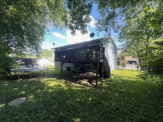 511 Turner Ave, Ashland, MO 65010 - back of property with a trampoline, a lawn, and a wooden deck