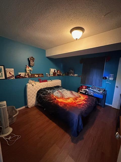 511 Turner Ave, Ashland, MO 65010 - bedroom with wood finished floors and a textured ceiling