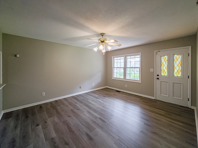 foyer entrance featuring dark wood-type flooring, a ceiling fan, a textured ceiling, and baseboards
