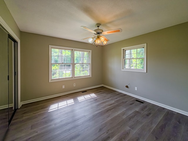 interior space with baseboards, dark wood-style floors, and a closet