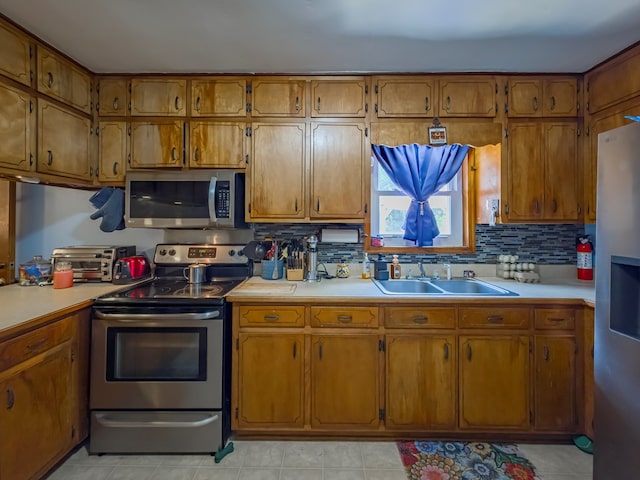 2222 Davis Ave, Tifton, GA 31794 - kitchen with stainless steel appliances, brown cabinets, light countertops, and a sink