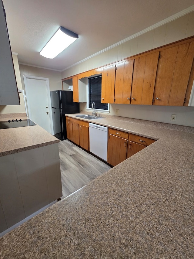 kitchen with brown cabinetry, crown molding, a sink, black appliances, and light wood finished floors