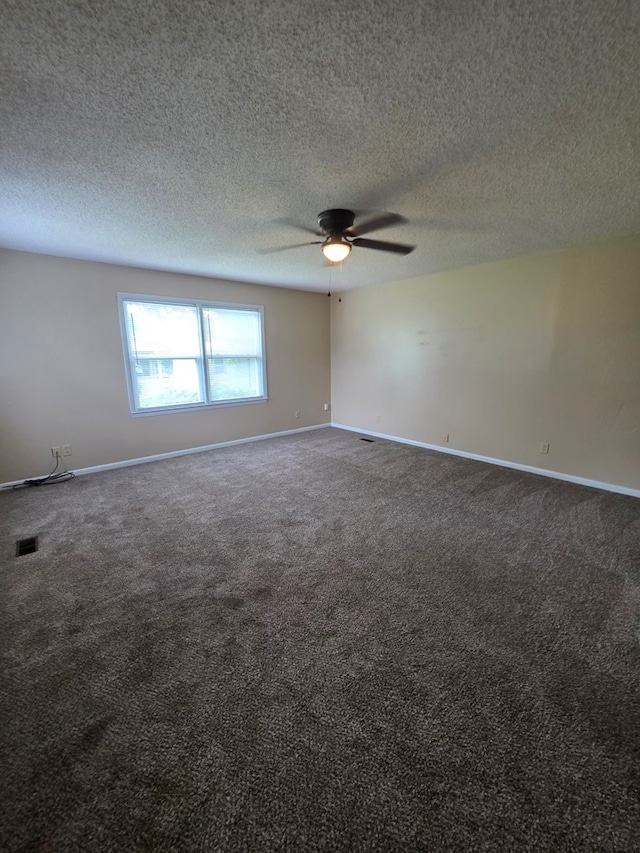 carpeted spare room featuring a ceiling fan, baseboards, visible vents, and a textured ceiling