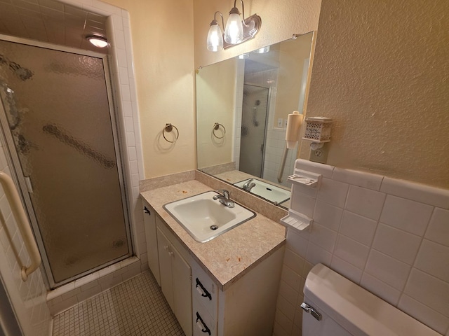 bathroom with tile patterned flooring, a shower stall, vanity, toilet, and a textured wall