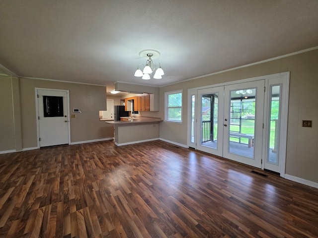 unfurnished living room featuring baseboards, ornamental molding, dark wood-style flooring, and a chandelier