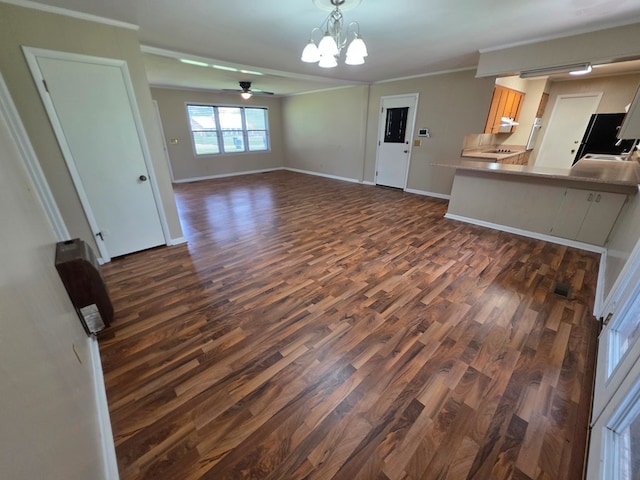 unfurnished living room with dark wood-type flooring, baseboards, crown molding, and ceiling fan with notable chandelier