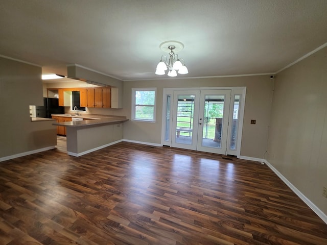 kitchen featuring baseboards, an inviting chandelier, a sink, and dark wood-type flooring