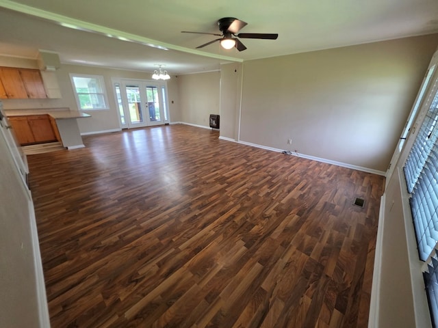 unfurnished living room with baseboards, visible vents, dark wood-style floors, and ceiling fan with notable chandelier