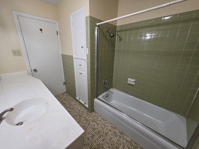 full bath with vanity, shower / bathtub combination, tile patterned floors, a wainscoted wall, and tile walls