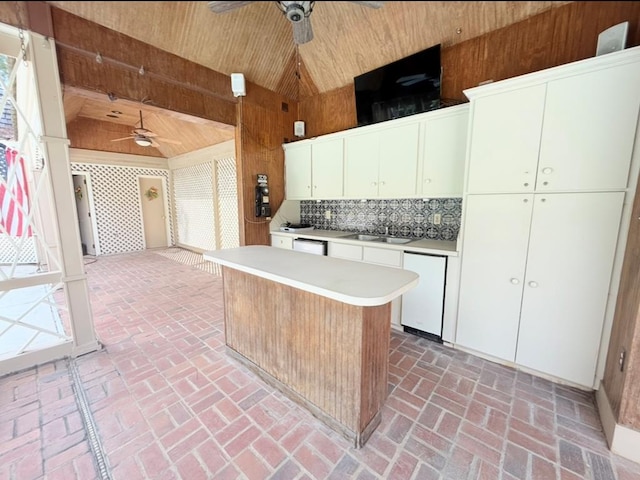 302 W 26th St, Tifton, GA 31794 - kitchen with a ceiling fan, wooden walls, wood ceiling, stainless steel dishwasher, and light countertops