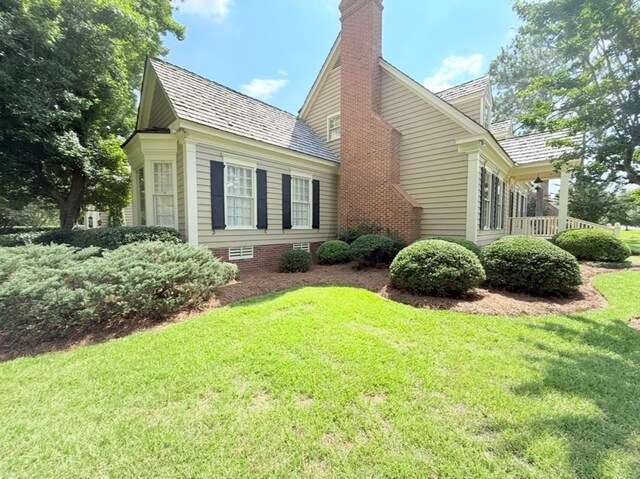 302 W 26th St, Tifton, GA 31794 - view of side of home with a chimney, a lawn, and a high end roof