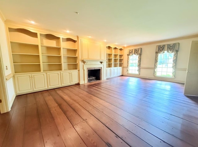 302 W 26th St, Tifton, GA 31794 - unfurnished living room with hardwood / wood-style flooring, crown molding, a fireplace, and built in shelves