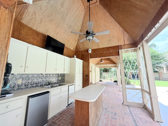 302 W 26th St, Tifton, GA 31794 - kitchen with a ceiling fan, high vaulted ceiling, light countertops, wood walls, and brick patterned flooring