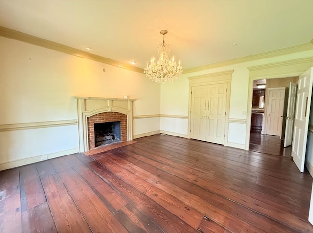 302 W 26th St, Tifton, GA 31794 - unfurnished living room featuring a chandelier, hardwood / wood-style flooring, ornamental molding, and a brick fireplace