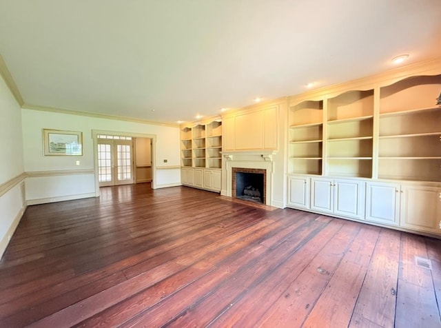 302 W 26th St, Tifton, GA 31794 - unfurnished living room with french doors, dark wood-style floors, crown molding, a fireplace with flush hearth, and built in shelves