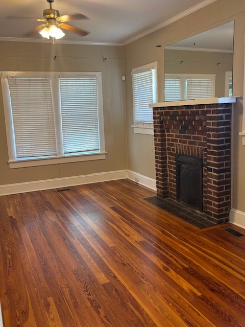 407 N Ridge Ave, Tifton, GA 31794 - unfurnished living room with wood finished floors, baseboards, ceiling fan, ornamental molding, and a brick fireplace